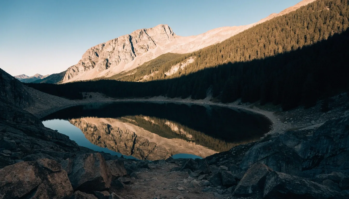 Valle glaciar de Aigüestortes con un lago de alta montaña reflejando las laderas de coníferas al atardecer